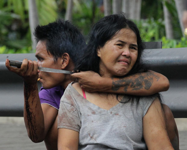 Homem mantém mulher refém nesta quinta-feira (5) em Bangcoc, na Tailândia (Foto: Sakchai Lalit/AP)