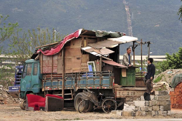 Chinês Huang Yitu (esq) construiu uma casa improvisada em cima de um caminhão (Foto: China Daily/Reuters)