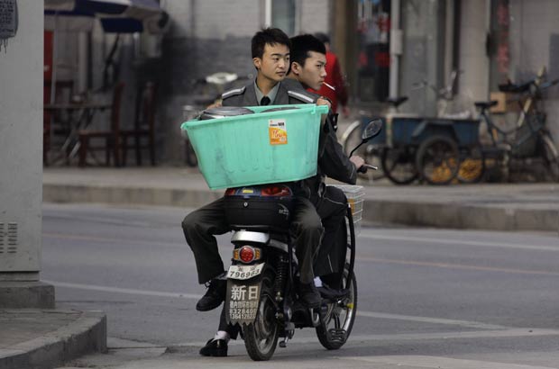 Passageiro foi flagrado de costas de moto na China. (Foto: Reuters)