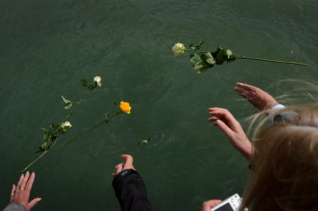 Moradores jogam flores no local da partida do Titanic nesta terça-feira (10) na cidade britânica de Southampton (Foto: AFP)