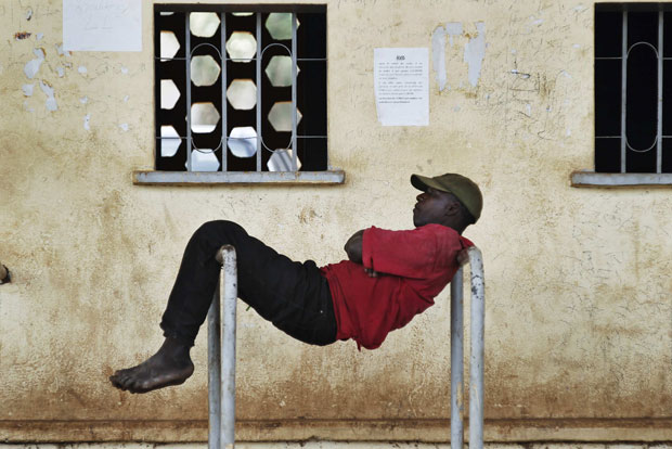 Homem encontra posição bizarra para descansar no Mali (Foto: Joe Penney/Reuters)