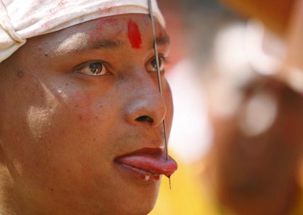 Os moradores acreditam que a prática, feita com uma fina barra de ferro, traz sorte para a região (Foto: Navesh Chitrakar/Reuters)