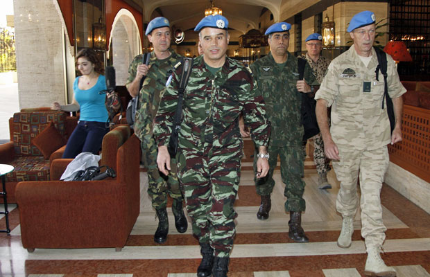 Observadores da ONU caminham por hotel de Damasco nesta segunda-feira (16) (Foto: Khaled al-Hariri/Reuters)