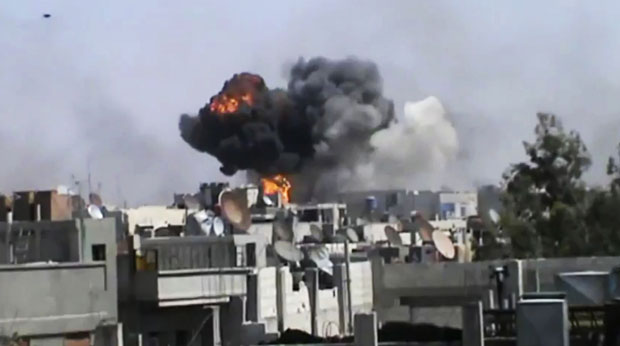 Imagem divulgada pela oposição mostra bombardeio de forças do governo à cidade síria de Homs nesta quarta-feira (18) (Foto: AP)