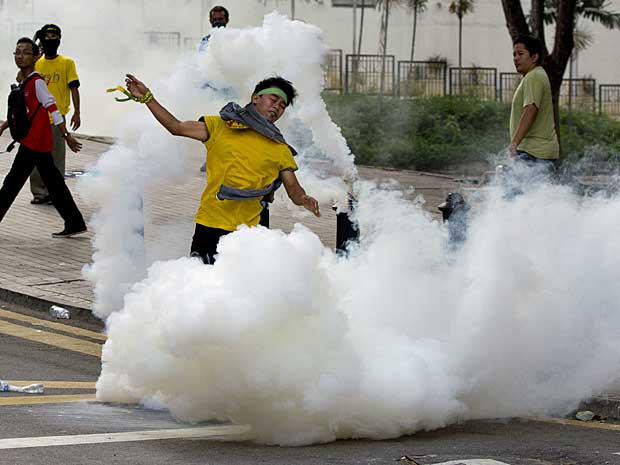 A polícia usa bomba de gás e canhões de água para controlar manifestação em Kuala Lumpur, na Malásia. (Foto: Mark Baker / AP Photo)