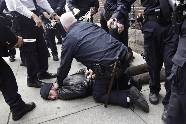 Manifestante é detido por um policial após protesto (Foto: Mary Altaffer/AP)