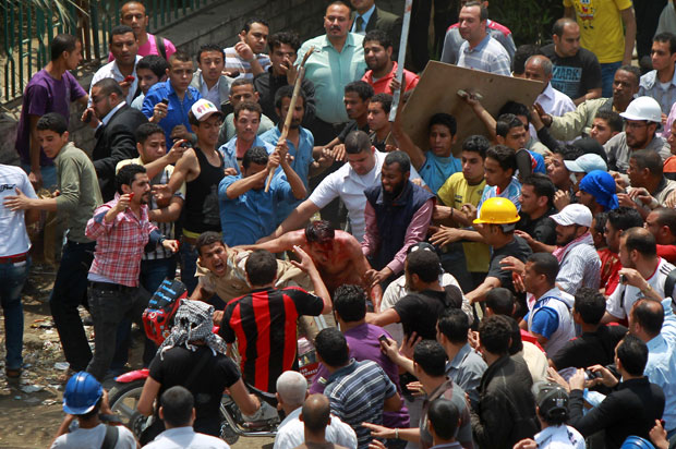 Homem é cercado e agredido durante protestos no Cairo, capital do Egito, nesta quarta-feira (2) (Foto: Reuters)