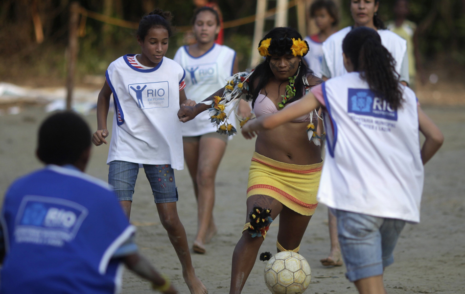Garota indígena joga futebol com residentes do Rio de Janeiro na "aldeia urbana" Kari-Oca, em Jacarepaguá