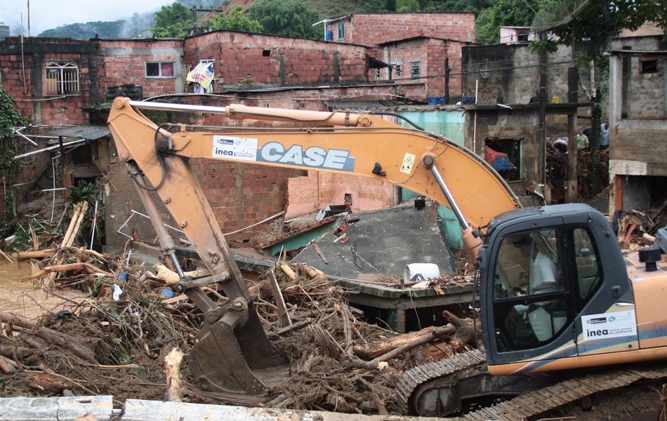 Tratores trabalham nos escombros causados pelo alagamento em Xerém em Duque de Caxias (RJ)