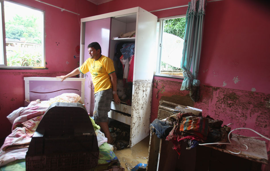 Homem mostra estragos em sua casa em Xerém, em Duque de Caxias.
