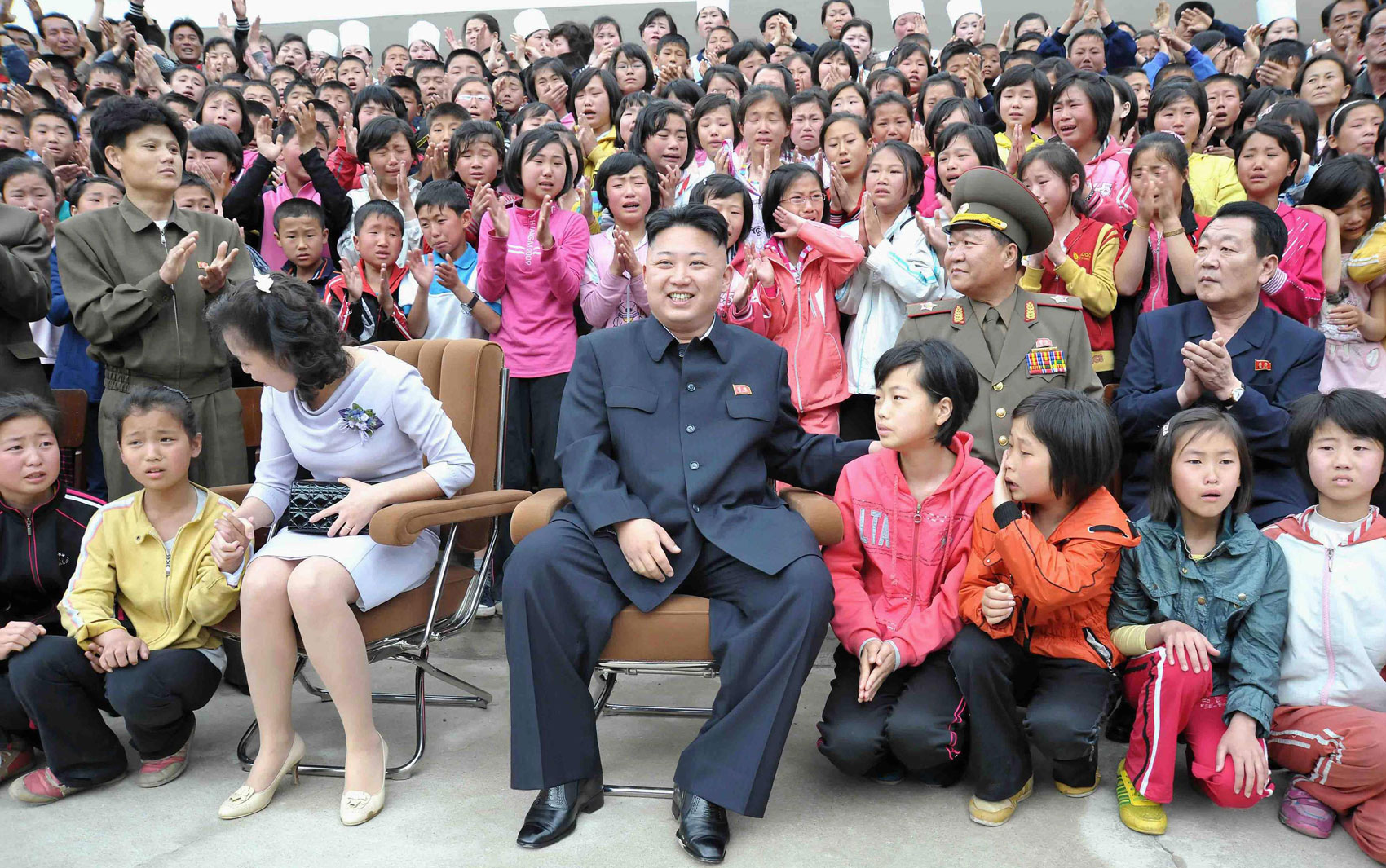 Ao lado de sua esposa, Ri Sol-ju, o ditador norte-coreano Kim Jong-un posa com crianças em lágrimas durante visita a um acampamento infantil ao pé do Monte Myohyang, na província norte-coreana de Phyongan do Norte.