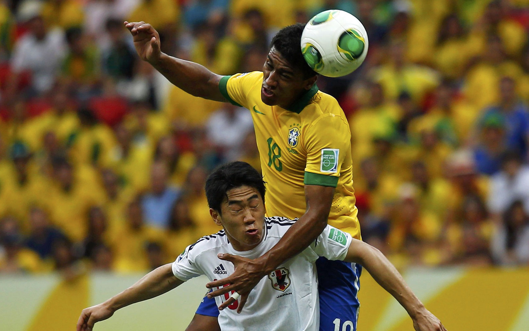 Paulinho em lance com o jogador japonês na disputa de estreia da Copa das Confederações