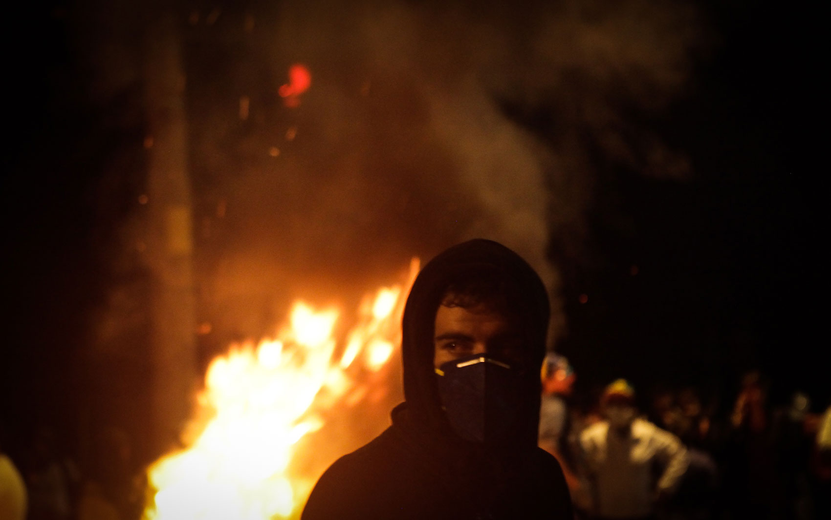 Em São Paulo, manifestante esconde o rosto durante protesto realizado em frente ao Palácio dos Bandeirantes, sede do governo paulista