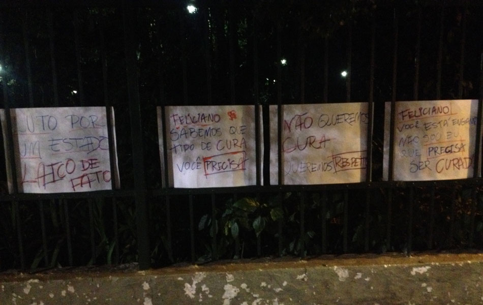 Cartazes colados na grade do Parque Trianom após o protesto contra a cura gay pedem estado laico e respeito.