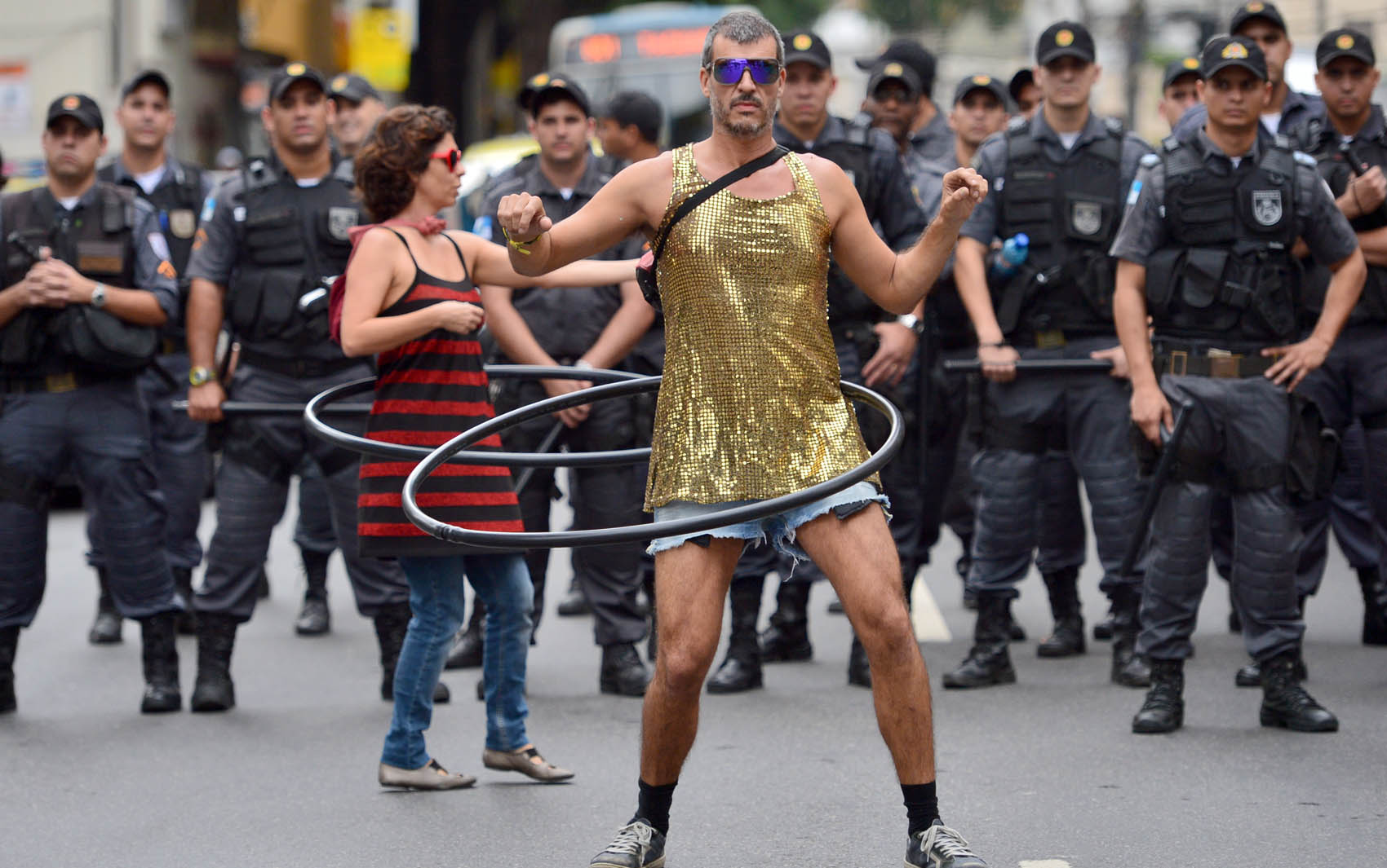 Rio de Janeiro: Manifestantes usam bambolê em frente ao cerco da Polícia Militar no entorno do estádio do Maracanã, onde a seleção brasileira enfrenta a Espanha pela final da Copa das Confederações neste domingo (30).