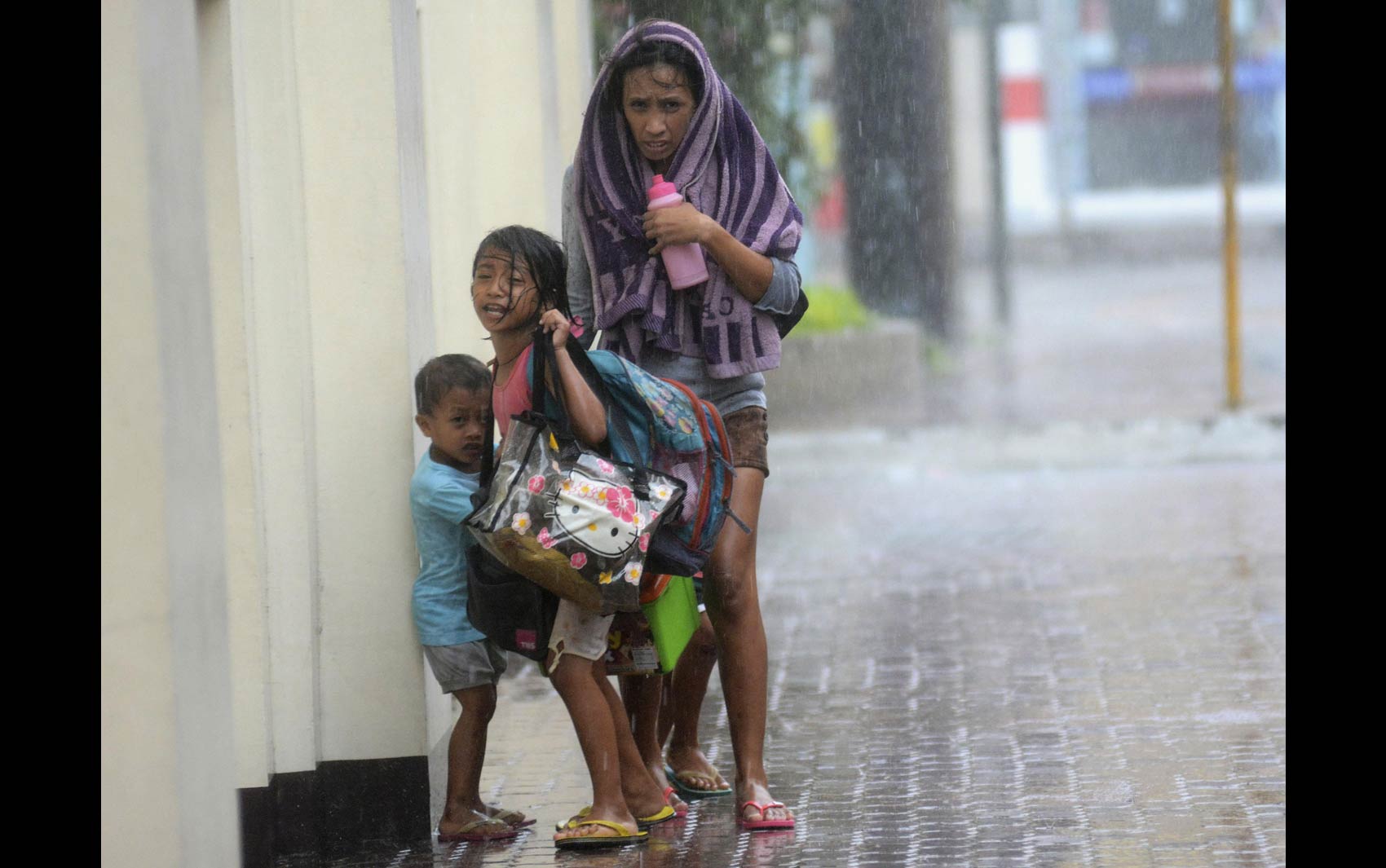 8/11 - Mulher busca refúgio com seus filhos durante a passagem do supertufão Haiyan em Cebu