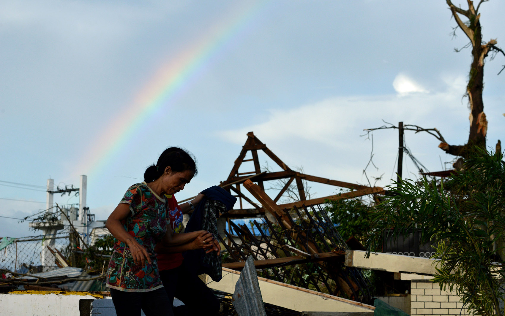 9/11 - Moradores andam por escombros de casas destruídas em Tacloban