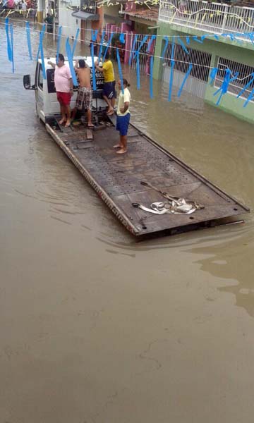 Moradores tentam resgatar carro alagado pertoda lagoa de São Conrado, em Natal
