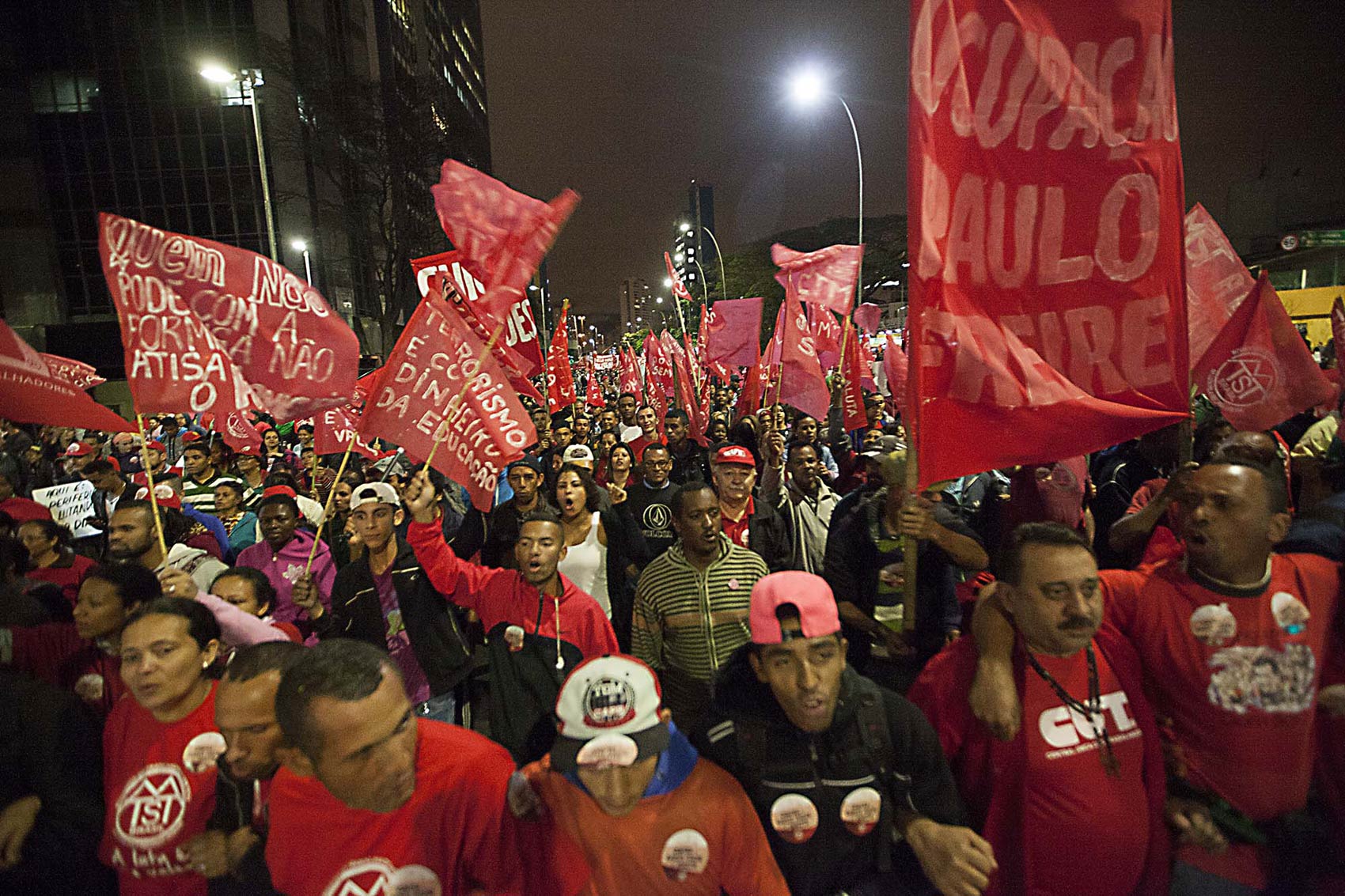 Manifestantes chegam à Avenida Paulista em passeata levando bandeiras vermelhas em defesa da democracia e contra a ameaça de golpe militar, em São Paulo