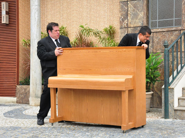 Jorginho (Leandro Hassum) e Pedrão (Marcius Melhem) carregam o piano que Babi (Alexandra Richter) vai dar de presente à mãe (Foto: Divulgação TV Globo)