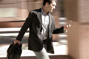 Andando e enviando SMS (Foto: StockPhoto)