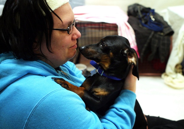  Kim Levan abraça seu cão Charlie em uma escola reservada para desabrigados (Foto: Getty Images/Reprodução)