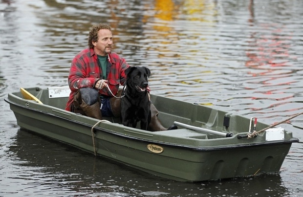 Ray Cilli e sua cadela sendo salvos do furacão Sandy por um boate em Little Ferry (Foto: Reuters/Reprodução