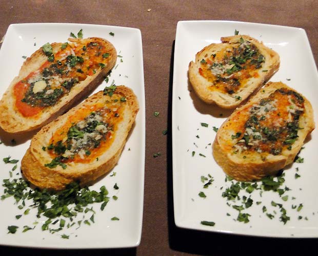 Bruschettas: fatias de pão com molho de tomate, temperos e queijo