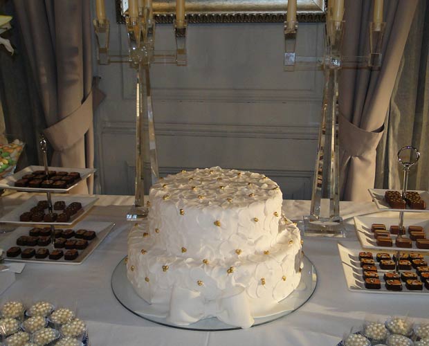 O bolo é todo decorado com detalhes dourados