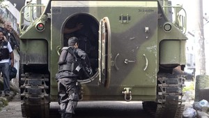 Soldado do Exército prestes a entrar em blindado durante operação no Complexo do Alemão