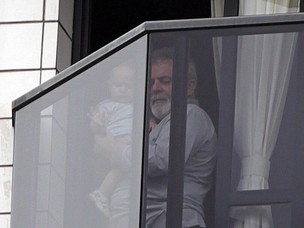 Lula com uma criança na sacada do apartamento onde mora, em São Bernardo (Foto: Marcos Alves / Agência O Globo)