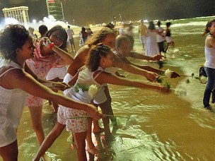 Pessoas jogam rosas no mar e fazem pedidos para 2012 (Foto: Divulgação/Poullainn Neuve)