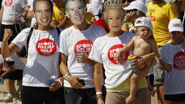 10/03 - Sábado - Fãs usam máscaras do Príncipe William, Príncipe Charles e Rainha Elizabeth em evento do Príncipe Harry no Rio (Foto: Reuters)