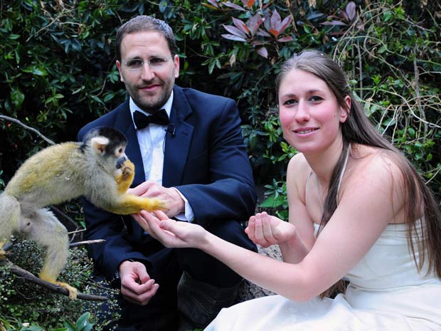 Funcionários do zoo Kate Sanders e Daniel Simmond posam para foto ao lado de macaco.