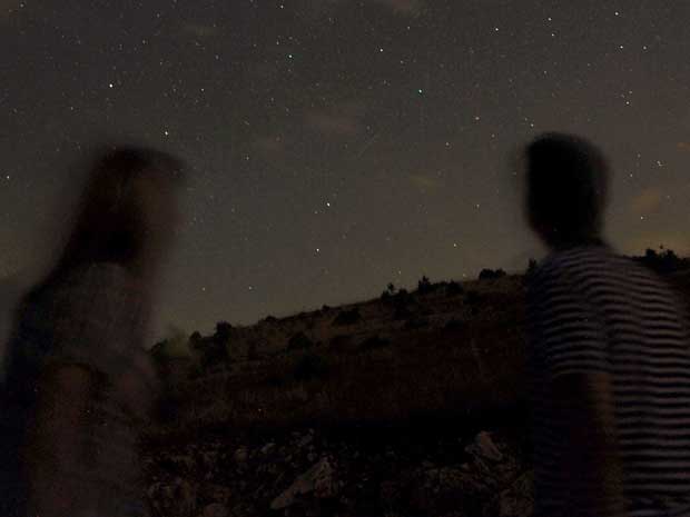 Foto de longa exposição em uma estrada montanhosa ao sul de Skopje, capital da Macedônia, registra os meteoros riscando o céu ao entrarem na atmosfera da Terra.