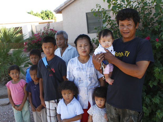 Hai Doo (à direita), refugiado de Miammar, com seus sete  filhos, esposa e pai em frente à casa da família em Phoenix, no Arizona