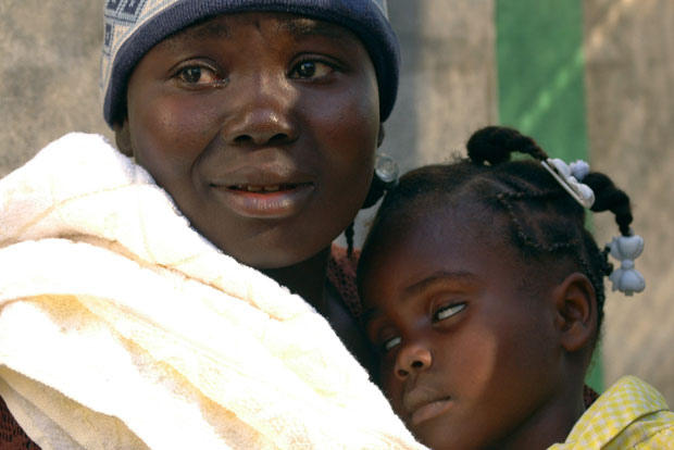 Haitiana ampara sua filha, com cólera, no Hospital Saint Catherine, na favela Cite-Soleil