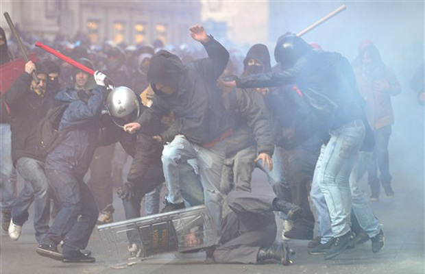 Policial é cercado e agredido por manifestantes nesta terça-feira (14) no centro de Roma.