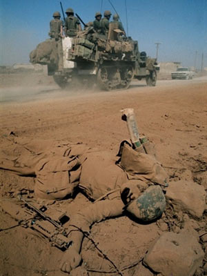 Veículo militar israelense passa por corpo de soldado sírio morto durante a guerra para tentar reaver Colinas do Golã, em 1967