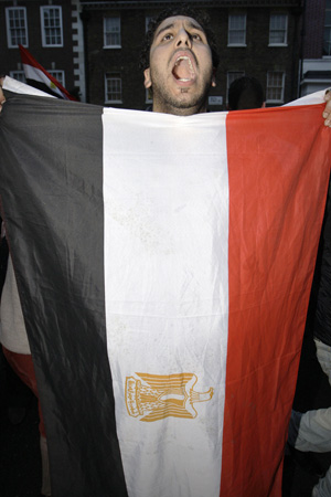 Egípcio, com bandeira do país, comemora o anúncio nesta sexta-feira (11) (Foto: AP)