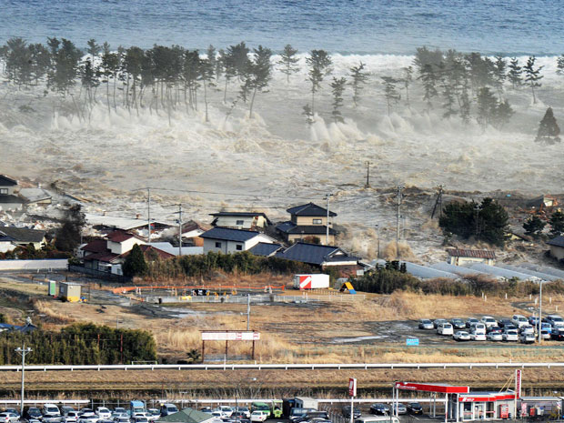 Ondas do tsunami atingem casas em Natori (Foto: AP)