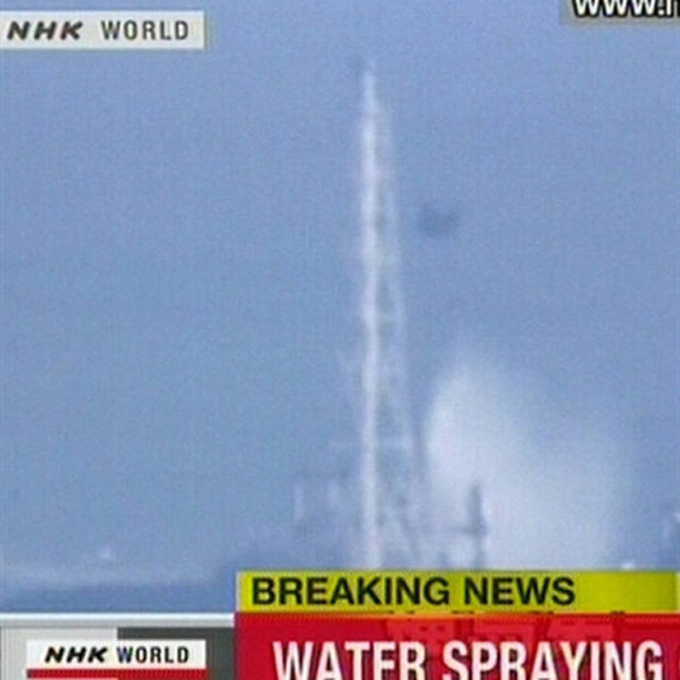 Imagem da TV japonesa mostra helicóptero militar lançando água sobre o reator 3 na manhã desta quinta (17) (Foto: AFP)