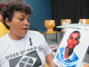 Débora Silva, presidente do movimento Mães de Maio, mostra foto do filho vítima dos ataques. (Foto: Caroline Hasselmann/G1)