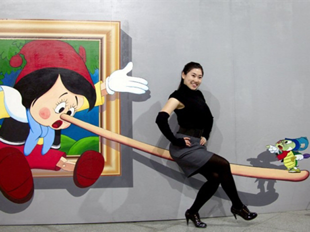 Mulher chinesa posa com uma pintura quadridimensional (4D) em uma exposição de arte contemporânea na província chinesa de Jilin, no sábado (14). A China ultrapassou a Grã-Bretanha como segundo maior mercado mundial de arte e antiguidades, em 2010, segundo relatório da Fine Art Fair Europeia (Tefaf). (Foto: AFP)