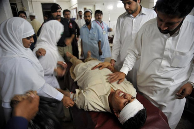 Médicoa atendem vítima de explosão em padaria em Nowshera. (Foto: AFP)