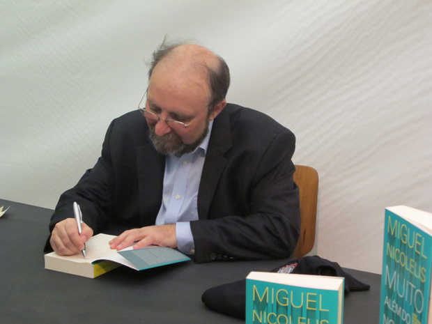 Miguel Nicolelis autografa um exemplar de 'Muito Além do Nosso Eu' (Foto: Tadeu Meniconi / G1)