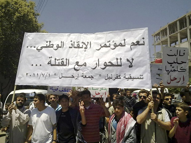 Manifestantes protestam contra o governo da Síria em Kfar Nebel, noroeste do país, nesta sexta-feira (1º). A foto foi feita por telefone celular por um dos ativistas (Foto: AP)