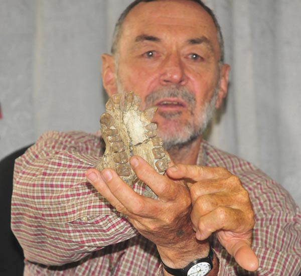 O paleontólogo Martin Pickford, do College de France de Paris, mostra crânio de um macaco de cerca de 20 milhões de anos encontrado na região de Karamoja, em Uganda (Foto: Ronald Kabuubi/AP)