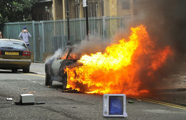 Carro em chamas é visto em rua de Hackney, Londres, nesta segunda (8) (Foto: Toby Melville/Reuters)
