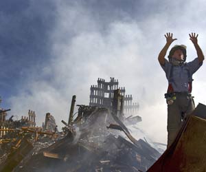 Bombeiro acena para colegas durante trabalho nos escombros do WTC, em 11/9 (Foto: The New York Times)